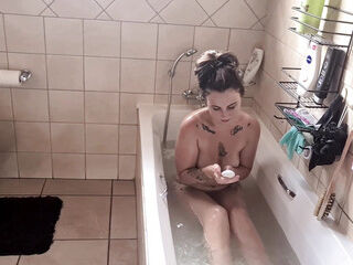 Tattooed young MILF taking a bath